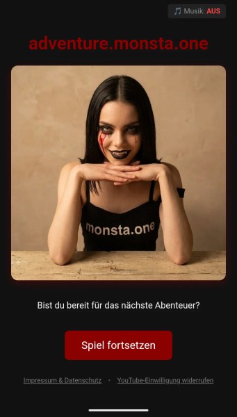 Eine Person mit schwarzen Haaren und auffälligem Make-up, die auf einem Tisch sitzt und in die Kamera lächelt, während sie ein T-Shirt mit der Aufschrift 'monsta.one' trägt. Im Hintergrund ist ein dunkler Bildschirm mit Text und Schaltflächen.